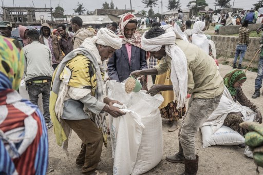Les personnes qui ont fui la guerre de May Tsemre, Addi Arkay et Zarima se rassemblent dans un camp de déplacés internes (PDI) temporairement construit pour recevoir leurs premiers sacs de blé du Programme alimentaire mondial (PAM) à Debark, à 90 kilomètres de la ville de Gondar, Éthiopie, le 15 septembre 2021 (Photo, AFP)