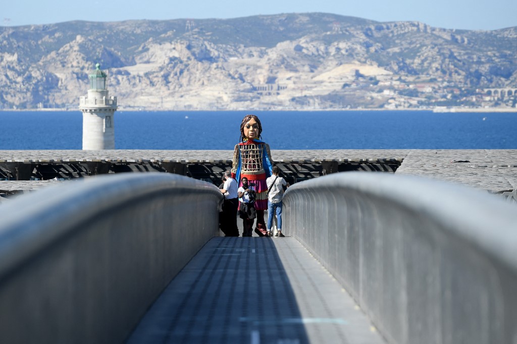 "Little Amal" est transporté à l'intérieur du musée Mucem à Marseille, le 22 septembre 2021, dans le cadre de "The walk", un festival d'art qui suit le parcours de Little Amal, une marionnette géante représentant une jeune réfugiée syrienne parcourant 8000 km (AFP)