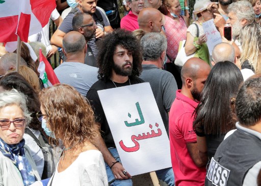 Des militants et des proches des victimes de l'explosion du port de Beyrouth lèvent des pancartes alors qu'ils manifestent le 29 septembre 2021 devant le palais de justice (Photo, AFP)