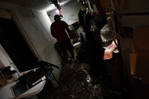 Eddie, un immigrant du Mexique, traverse son appartement au sous-sol inondé dans un quartier du Queens qui a connu des inondations massives et de nombreux décès à la suite d'une nuit de vent violent et de pluie provenant des restes de l'ouragan Ida le 03 septembre 2021 à New York. (Spencer Platt/Getty Images/AFP)