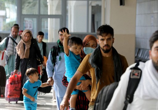 Des ressortissants afghans à double nationalité se préparent à embarquer sur un vol Qatar Airways à l'aéroport international de Kaboul Hamid Karazai à destination de Doha le 10 septembre 2021. Les doubles ressortissants du Canada, de Grande-Bretagne, d'Allemagne et de France ont été évacués d'Afghanistan vers le Qatar. (Marwan Tahtah / MOFA)