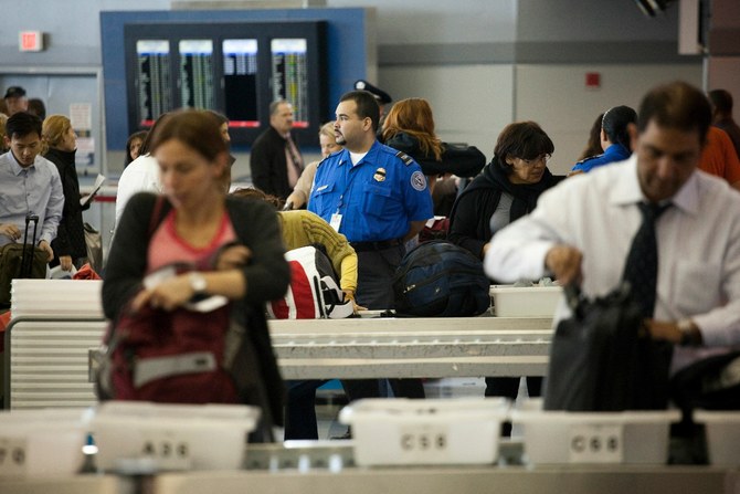 Les passagers déposent leurs effets personnels dans des poubelles avant de passer le contrôle de sécurité des passagers au terminal 8 de l'aéroport international John F. Kennedy le 22 octobre 2010. (Fichier/AFP)