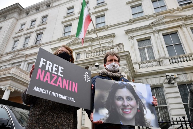 Richard Ratcliffe, époux de Nazanin Zaghari-Ratcliffe, l’Anglo-iranienne qui travaille avec une association humanitaire tenant une photo de sa femme devant l'ambassade d'Iran à Londres (Dossier/AFP)