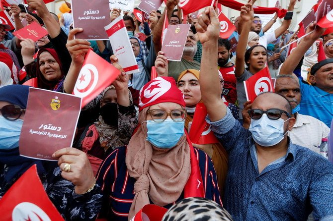 Des manifestants brandissent des drapeaux et des copies de la constitution tunisienne lors d'une manifestation contre la mainmise du président tunisien Kais Saied le 26 septembre 2021(Reuters)