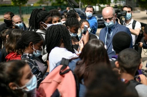 Le ministre français de l'Éducation, de la Jeunesse et des Sports Jean-Michel Blanquer (à droite) rencontre les élèves du collège Le Saussay dans la banlieue parisienne de Ballancourt-sur-Essonne le 28 mai 2021 lors d'une visite avec l'épouse du président français dédiée à la lutte contre le harcèlement. (Stephane de Sakutin/AFP)