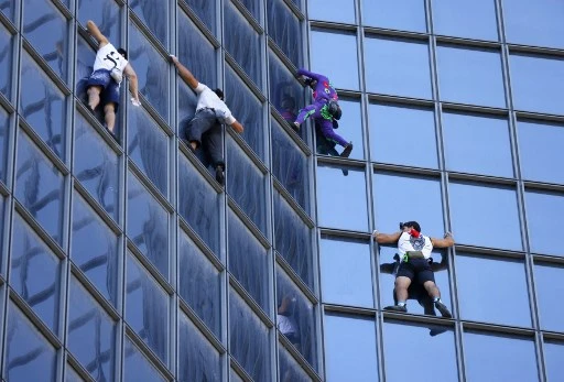 Alain Robert, surnommé le «Spider-Man français», a escaladé mardi à mains nues une tour du quartier d'affaires de La Défense (Hauts-de-Seine), en lisière de Paris, pour marquer son opposition au pass sanitaire (Photo, AFP)