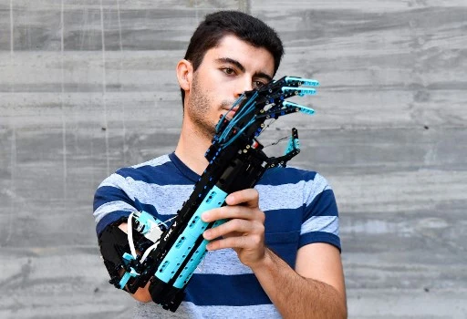 Détenteur du record du monde Guinness 2017 et vainqueur du Lego Masters France 2020, l'étudiant universitaire andorran David Aguilar, 22 ans, atteint du syndrome de Poland, pose avec son bras prothétique auto-construit, fabriqué avec des pièces Lego, à Sant Cugat del Valles, près de Barcelone le 9 septembre 2021. (Pau Barrena/ AFP)