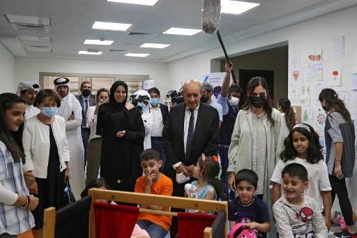Le ministre français des Affaires étrangères Jean-Yves Le Drian, accompagné de la ministre adjointe des Affaires étrangères du Qatar Lolwah al-Khater, rend visite à des réfugiés afghans dans un complexe de logements à Doha le 13 septembre 2021 (Photo, AFP)