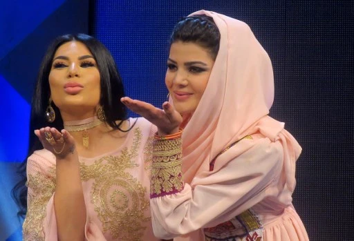 Sur cette photo prise le 9 mars 2017, l’Afghane Aryana Sayeed (à droite), juge du concours de musique télévisé 'Afghan Star', pose avec la jeune concurrente Zulala Hashemi à Kaboul. (Anne Chaon / AFP)