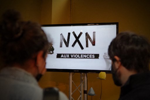 Des spectateurs regardent un clip vidéo sur un écran, dans le cadre d'une campagne de sensibilisation sur les violences sexuelles et discriminatoires avec le "domaine culturel", au festival de musique "Printemps de Bourges", à Bourges dans le centre de la France, le 23 juin 2021. (Guillaume Souvant/AFP)