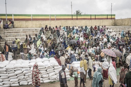 Des personnes ayant fui la guerre de May Tsemre, Addi Arkay et Zarima se rassemblent dans un camp temporaire de déplacés internes (PDI), pour recevoir leurs premiers sacs de blé du Programme alimentaire mondial (PAM) à Debark, à 90 kilomètres de la ville de Gondar, Éthiopie, le 15 septembre 2021. (Amanuel Sileshi / AFP)