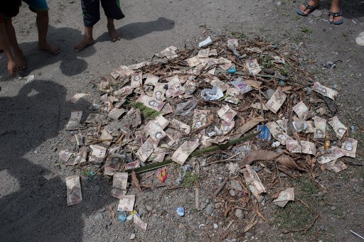 Vue d'un tas de détritus avec des billets de bolivar vénézuélien inutilisés dans une rue de la ville de Puerto Concha, dans l'État de Zulia, au Venezuela, le 8 septembre 2021. (Federico Parra/ AFP)