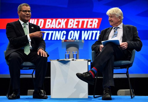 Le président britannique de la COP26, Alok Sharma (à gauche), réagit lors d'une conversation avec Stanley Johnson le troisième jour de la conférence annuelle du Parti conservateur au centre des congrès de Manchester Central à Manchester, dans le nord-ouest de l'Angleterre, le 5 octobre 2021. (Ben Stansall / AFP)
