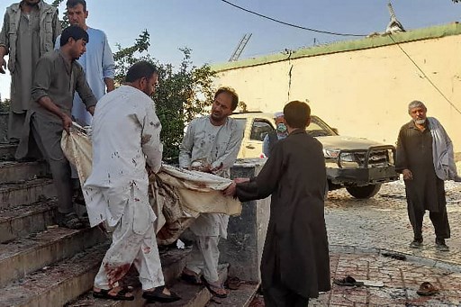 Des Afghans transportent le cadavre d'une victime dans une ambulance après un attentat à la bombe dans une mosquée de Kunduz le 8 octobre 2021. (AFP)