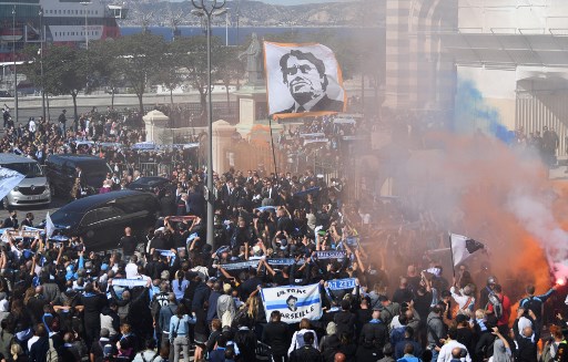 Le cercueil de Bernard Tapie, magnat des affaires, acteur et homme politique français, est soulevé dans un fourgon funéraire après ses funérailles à la cathédrale Major de Marseille, dans le sud-est de la France, le 8 octobre 2021. (Clement Mahoudeau/AFP)
