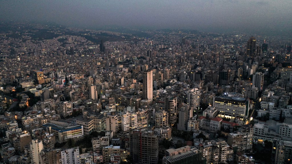 Cette photo prise le 11 octobre 2021 montre une vue aérienne au coucher du soleil de la capitale libanaise Beyrouth, avec des bâtiments dans l'obscurité lors d'une panne de courant. (AFP)