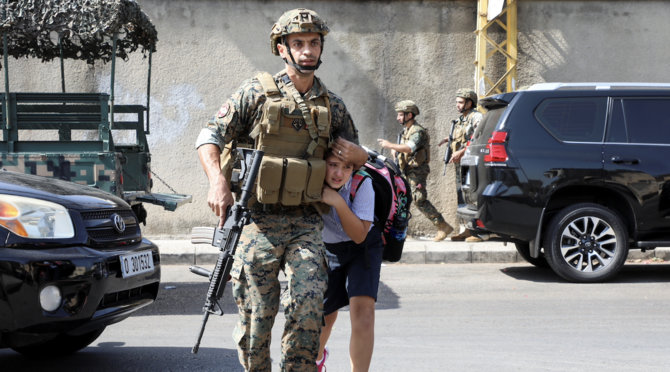 Un soldat aidant une écolière à rejoindre ses parents, après qu'une fusillade a éclaté à Beyrouth, le 14 octobre 2021. (Reuters)