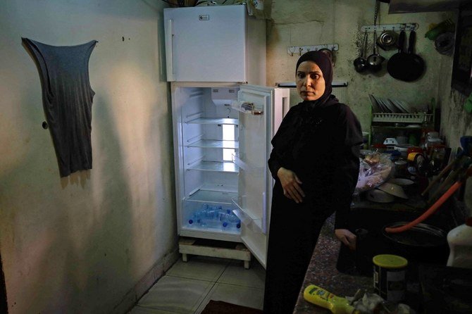 Une Libanaise à côté de son réfrigérateur vide dans son appartement de la ville portuaire de Tripoli, au nord de Beyrouth. (Dossier/AFP)