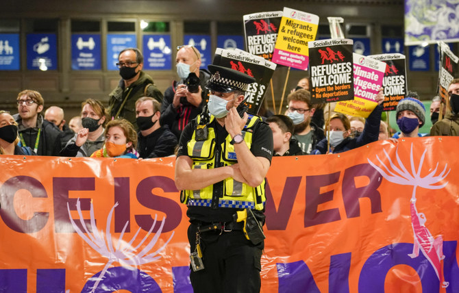 Des militants contre le changement climatique brandissent des banderoles à la gare centrale de Glasgow, en Écosse, en amont de la Conférence des Nations Unies sur les changements climatiques (COP26), samedi 30 octobre 2021. (AP)