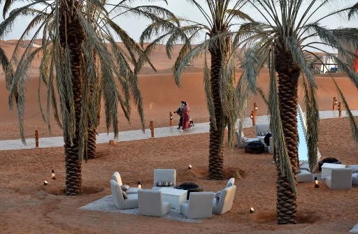 Des visiteurs marchent sous les palmiers de la "Riyad Oasis", dans le désert de Thumamah à la périphérie de la capitale saoudienne, le 1er février 2021. (Fayez Nureldine / AFP)