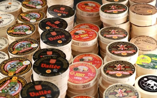 Cette photo d'archive prise le 22 février 2020, montre différents packs de fromage français "Camembert de Normandie" au lait cru de vache lors de la journée d'ouverture du 57e Salon international de l'agriculture. (Ludovic Marin / AFP)