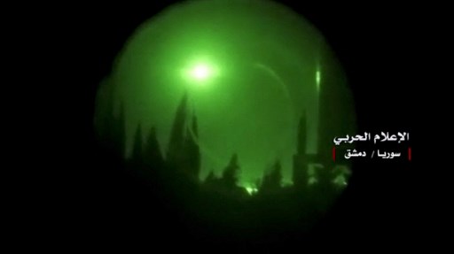 Une photo publiée le 14 avril 2018 sur la page Twitter du compte "Central War Media" du Hezbollah montre des images nocturnes de fusées éclairantes au-dessus de Damas vues à travers un dispositif de vision nocturne alors que des frappes occidentales auraient frappé des bases militaires syriennes et des centres de recherche chimique dans et autour de la Syrie. (Polycopié / STR / MÉDIA MILITAIRE CENTRAL DU GOUVERNEMENT SYRIEN / AFP)