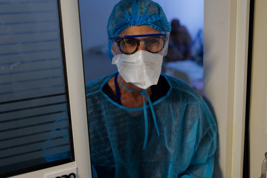 Un soignant pose avec un masque facial avant de rendre visite à des patients infectés par Covid19 au CHU Pasteur de Nice, le 25 février 2021.(AFP)
