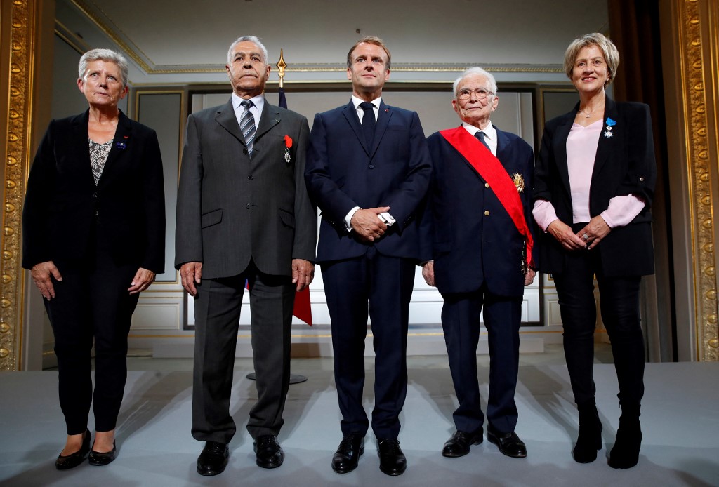 Le général François Meyer, Salah Abdelkrim et Bornia Tarall, posent avec le président français Emmanuel Macron et la ministre déléguée à la Défense Geneviève Darrieussecq après avoir été récompensés lors d'une cérémonie à la mémoire des Harkis, Algériens qui a aidé l'armée française dans la guerre d'indépendance algérienne, à l'Elysée à Paris, le 20 septembre 2021. (AFP)