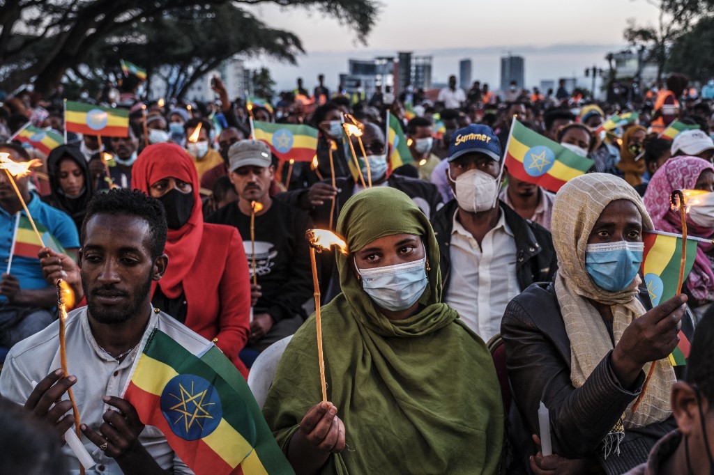 Des gens tiennent des bougies et des drapeaux éthiopiens lors d'un service commémoratif pour les victimes du conflit du Tigré à Addis-Abeba, en Éthiopie, le 3 novembre 2021. (AFP)