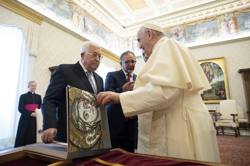 Sur cette photo prise et publiée le 4 novembre 2021 par les médias du Vatican, le pape François (à droite) et le président palestinien Mahmoud Abbas (2e à gauche) échangent des cadeaux lors d'une audience privée au Vatican. (AFP)
