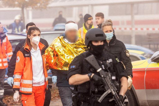 Des policiers et des secouristes marchent avec un homme détenu le 6 novembre 2021 à Seubersdorf, dans le sud de l'Allemagne, après que plusieurs personnes aient été blessées lors d'une attaque au couteau contre un train à grande vitesse. (AFP)