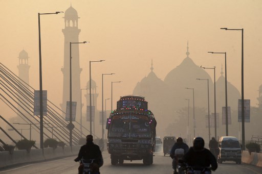 Des véhicules se frayent un chemin dans des conditions de smogg intense à Lahore le 17 novembre 2021. (Arif Ali / AFP)