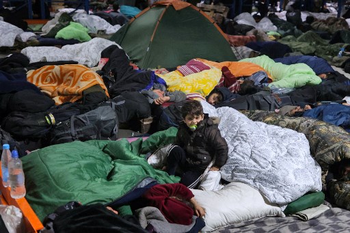Migrants parqués dans le centre de transport et de logistique près du poste frontière de Bruzgi à la frontière biélorusse-polonaise dans la région de Grodno le 19 novembre 2021. (Leonid Shcheglov/Belta/AFP)