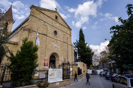 Des visiteurs se dirigent vers l'église catholique romaine de la Sainte-Croix par la zone tampon des Nations Unies près de la porte de Paphos de la capitale chypriote divisée Nicosie le 24 novembre 2021. Le pape François est attendu à Chypre la semaine prochaine. (Amir Makar / AFP)