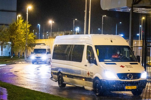 Une camionnette de la Croix-Rouge transportant des passagers de vols en provenance d'Afrique du Sud qui ont été testés positifs pour Covid-19 se rend dans un hôtel où ils seront mis en quarantaine le 27 novembre 2021 à l'aéroport Schiphol d'Amsterdam. (Laurens Bosch / ANP / AFP)