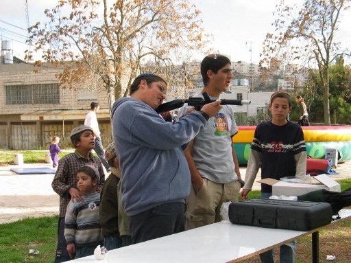 Des jeunes colons s'amusent au paintball, aux abords du Caveau des Patriarches, le 23 décembre 2003 à Hébron. Plusieurs organisations juives se déplacent durant les vacances dans les colonies juives de Cisjordanie pour y installer des jeux destinés aux enfants. (Tuvia Benyitzhak/AFP)