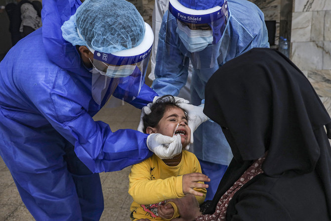 Une jeune fille réagit au moment où un professionnel de la santé effectue un prélèvement nasal dans une clinique à l’occasion d’un dépistage de Covid-19 dans la ville de Gaza. (AFP/File Photo)