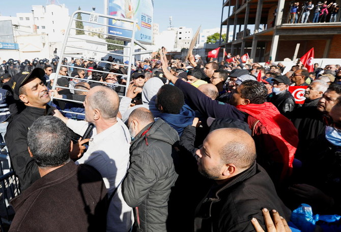 Des manifestants tentent de lever les barricades lors d'une manifestation contre la prise des pouvoirs par le président tunisien Kais Saied, devant le parlement, à Tunis, Tunisie, le 14 novembre 2021. (Reuters)