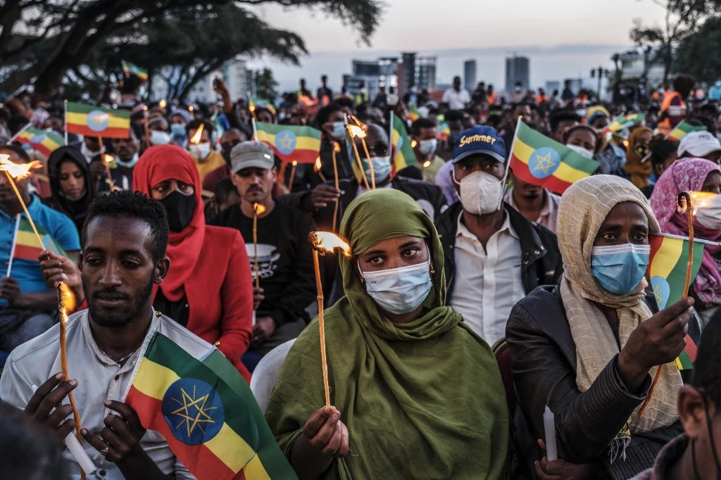 Des gens tiennent des bougies et des drapeaux éthiopiens lors d'un service commémoratif pour les victimes du conflit du Tigré à Addis-Abeba, en Éthiopie, le 3 novembre 2021. (AFP)