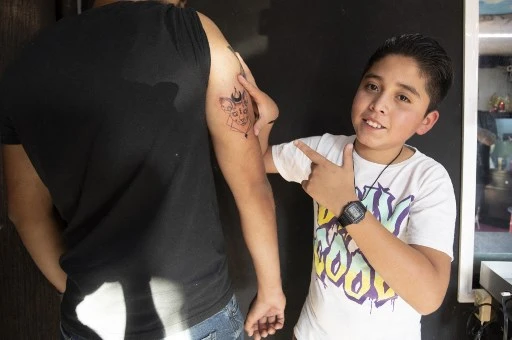 Brandon Burgos pose après avoir tatoué une personne dans la ville de Puebla, dans l'État de Puebla, au Mexique, le 10 novembre 2021. Brandon Burgos brandit soigneusement une machine à tatouer dans le studio de son père, dans le centre du Mexique. Il n'a que 11 ans, mais l'écolier a déjà une trentaine de tatouages à son actif. (Juan Carlos Sanchez / AFP)