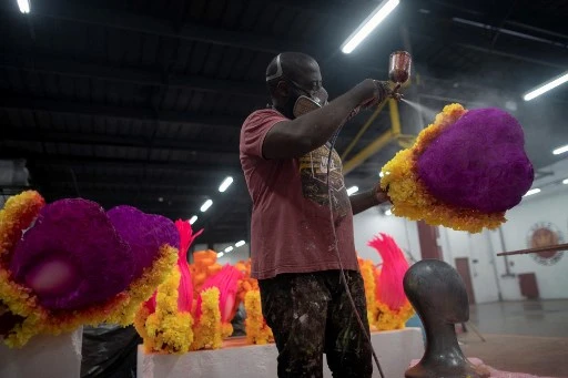 Un ouvrier de l'école de samba de Viradouro prépare des coiffes au quartier général du groupe, à la Cidade do Samba (Ville de Samba), où sont fabriqués les costumes et les chars pour le carnaval de Rio, en vue du carnaval de 2022 à Rio de Janeiro, Brésil, le 12 novembre, 2021.(Mauro Pimentel/AFP)