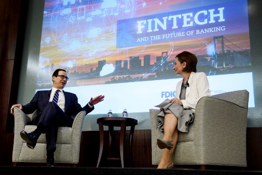 La présidente de la Federal Deposit Insurance Corporation (FDIC), Jelena McWilliams (à droite), écoute pendant que le secrétaire américain au Trésor Steven Mnuchin s'exprime lors d'une conférence sur « Les technologies financières et l'avenir de la banque », à la FDIC le 24 avril 2019, à Arlington, Virginie. (Brendan Smialowski/AFP)