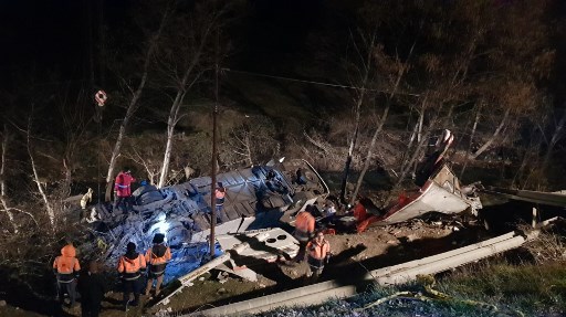 Des secouristes inspectent la carcasse d’un bus qui a plongé d'une route de montagne dans un ravin de la province de Mazandaran, à 150 kilomètres (90 miles) au nord-est de Téhéran, le 9 janvier 2020. (Reza Parsa/Agence De Presse Mizan/AFP)