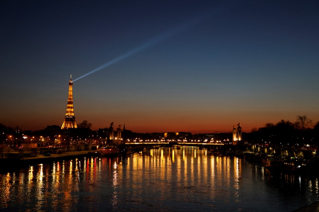 Vue générale de la Tour Eiffel illuminée au coucher du soleil à Paris, le 20 mars 2021 (AFP)