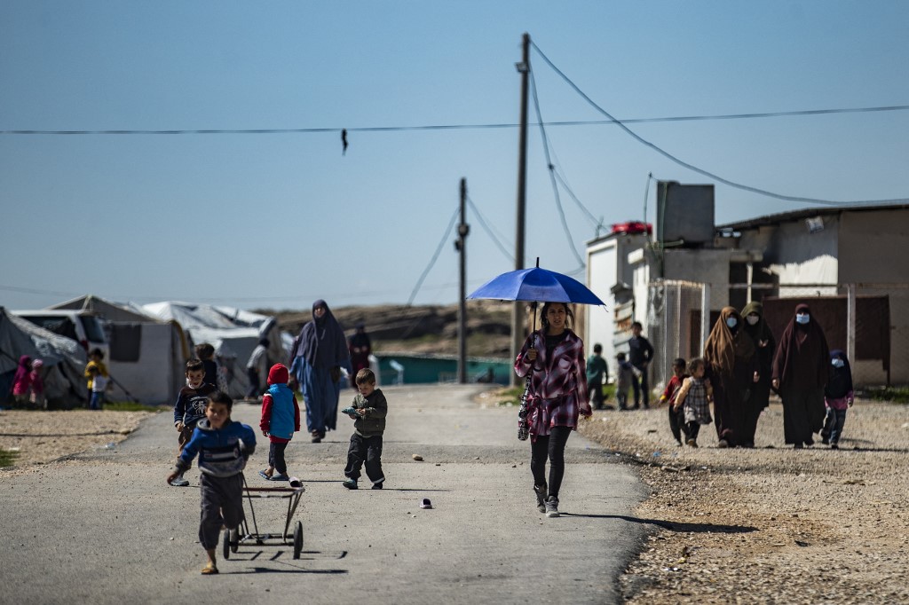 Des femmes avec des enfants marchent au camp Roj, où sont détenus des proches de personnes soupçonnées d'appartenir au groupe État islamique (EI), dans la campagne près d'al-Malikiyah (Derik) dans la province syrienne de Hasakah, dans le nord-est, le 28 mars 2021. (Photo,AFP)