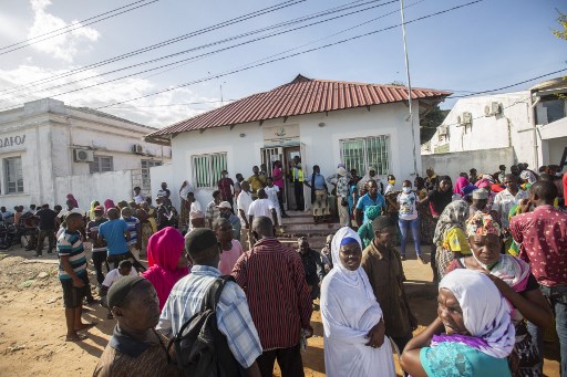 Plus d'une centaine de femmes et d'hommes attendent aux abords du port maritime de Pemba l'arrivée éventuelle d'un bateau transportant leurs proches évacués des côtes d'Afungi et de Palma après l'attaque par les forces armées contre la ville de Palma le 31 mars. 2021. (Alfredo Zuniga / AFP)