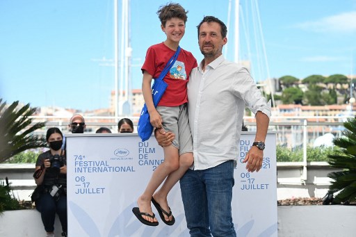 Le photographe français Vincent Munier pose avec son fils Simon lors d'un photocall pour le film "La Panthère des Neiges" dans le cadre de la sélection Cinéma Pour le Climat à la 74e édition du Festival de Cannes, dans le sud de la France, le 14 juillet , 2021. (Christophe Simon/AFP)