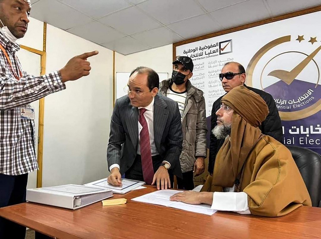 Une photo publiée par la page Facebook du Haut-Comité national libyen le 14 novembre 2021 montre Seif al-Islam Kadhafi (à gauche), fils du dirigeant libyen assassiné Mouammar Kadhafi, s’inscrivant pour se présenter aux élections présidentielles de décembre, dans la ville de Sebha, dans le sud de la Libye. ( Haut Conseil électoral national libyen FB Page / AFP)
