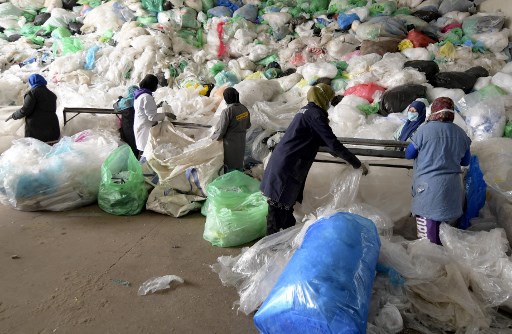 Des employés d'AFREC African Recycling, trient des tas de déchets plastiques à l'installation de recyclage de la zone industrielle de Mghira, près de la capitale tunisienne Tunis, le 25 novembre 2021. (Fethi Belaid/AFP)