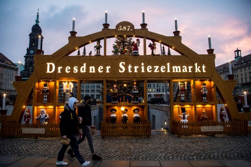 Des jeunes au marché de Noël traditionnel Striezelmarkt sur la place Alt Markt de Dresde le 6 décembre 2021. Le marché saisonnier, l'un des plus anciens d'Allemagne, devait ouvrir du 22 novembre au 24 décembre 2021, mais a été contraint de fermer en raison d'une augmentation des infections à Covid-19 dans l'État de Saxe. (John Macdougall/AFP)